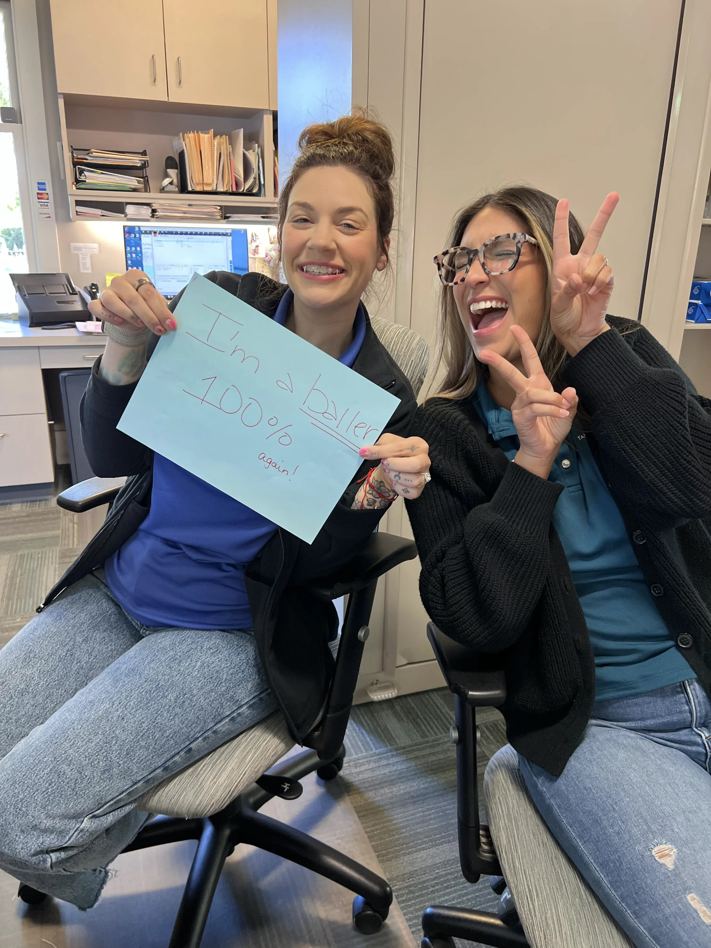 Two Tan Orthodontics team members celebrating a 100% day