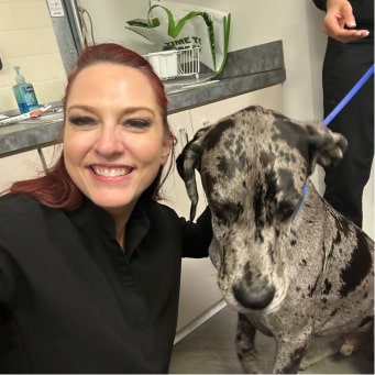One of our Straight Consulting team members smiling with a dog